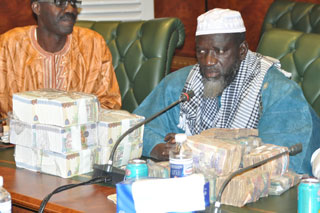 President SIC Momodou Lamin Touray with stash of Cash